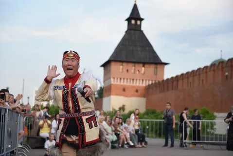 Этно-музыкант в национальном костюме выступает на фоне Тульского кремля