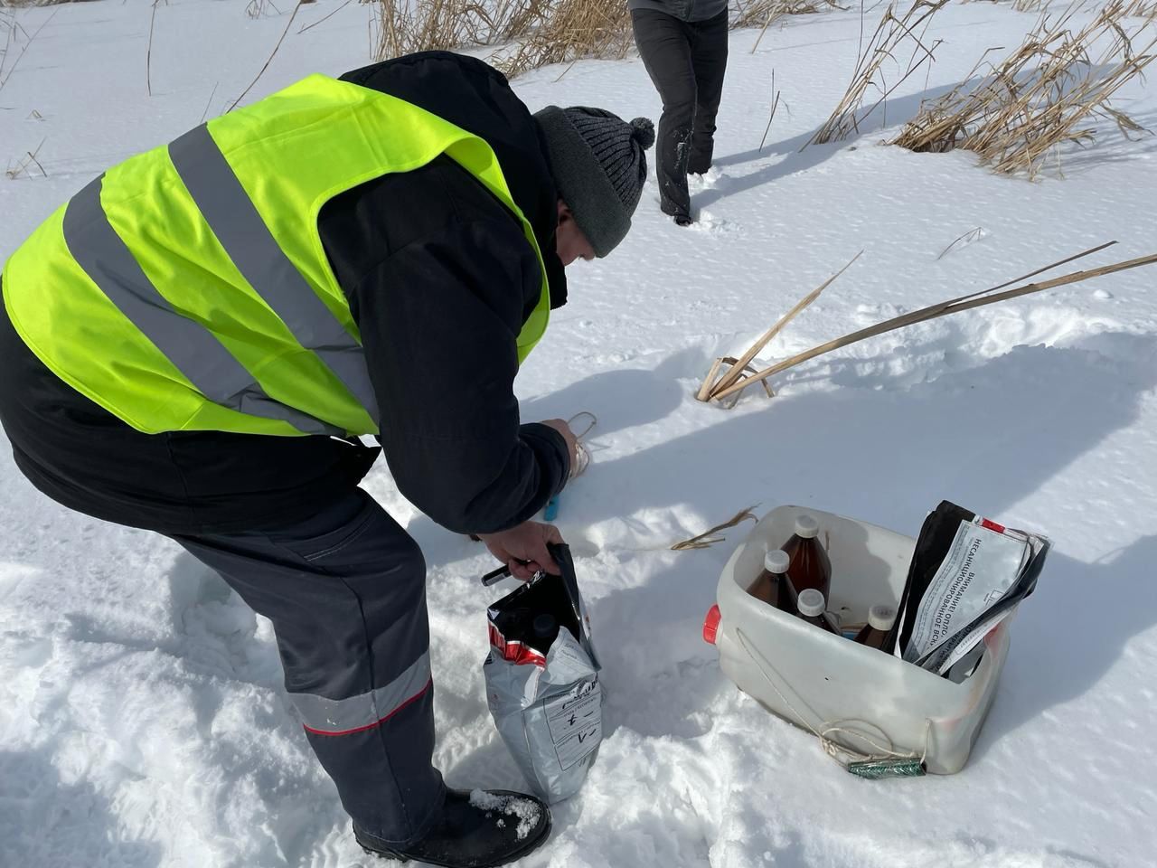 Специалист берёт пробы воды из реки Венёвки